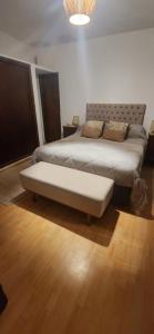 a bedroom with a king sized bed with a bench at Moramay in Punta del Este