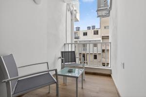 a balcony with two chairs and a glass table at Contemporary Retreat in St. Paul's Bay