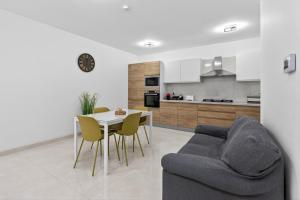 a living room with a couch and a table with chairs at Contemporary Retreat in St. Paul's Bay