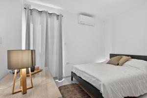 a bedroom with a bed and a table with a lamp at Contemporary Retreat in St. Paul's Bay