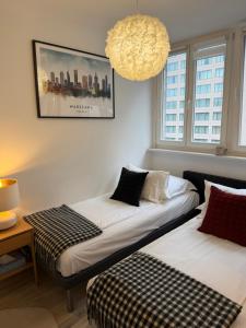 zwei Betten in einem Zimmer mit einem Bild an der Wand in der Unterkunft Apartament Centrum Warszawy Pereca in Warschau