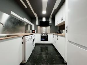 a kitchen with white cabinets and a black floor at Estudio en Sol (G) in Madrid