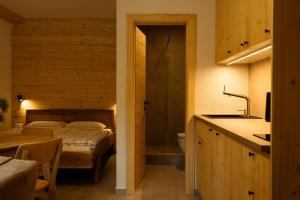 a bedroom with a bed and a bathroom with a sink at YASNA Apartments in Demanovska Dolina