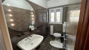 ein Badezimmer mit Waschbecken, Toilette und Spiegel in der Unterkunft Casa Falco in Urbania + 19 Fotos