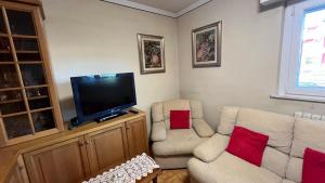 ein Wohnzimmer mit zwei Stühlen und einem Flachbildfernseher in der Unterkunft Casa Falco in Urbania