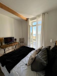 ein Schlafzimmer mit einem großen Bett und einem Fenster in der Unterkunft Villa Ô Dunes in Châtelaillon-Plage