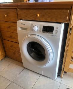 a white washing machine in a kitchen under a counter at Chalet des Caraïbes in Batroûn