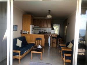 a living room with a couch and a kitchen at Chalet des Caraïbes in Batroûn