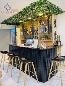 eine Bar mit Hockern und einem Laptop darauf. in der Unterkunft DOJ WORLD in Ikeja