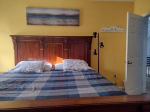 une chambre avec un lit avec une tête de lit en bois dans l'établissement Ventnor Island Beach House, à Ventnor City