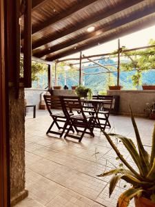 un patio con 2 panche e un tavolo con piante di Villa dei Filari a Tramonti