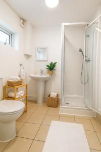ein Badezimmer mit Dusche, Toilette und Waschbecken in der Unterkunft Spacious double room close to Wimbledon Park station, 20 min to central in London