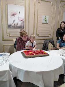 a woman holding a baby in front of a cake at Chez les sœurs in Igé