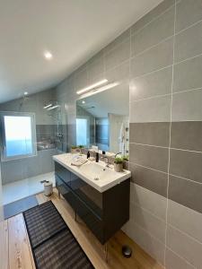 ein Badezimmer mit Waschbecken und großem Spiegel in der Unterkunft Villa Ô Dunes in Châtelaillon-Plage