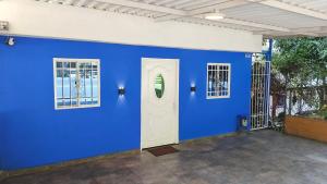 a blue wall with a white door and windows at Casa Terraza in El Zaino