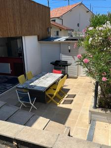 een patio met een tafel en stoelen bij Villa Josèphe in Capbreton
