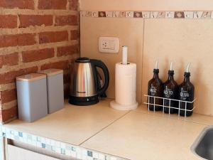 a counter with a coffee pot and bottles on it at QUINTA BELEN Cañuelas in La Porteña