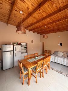 a dining room with a table and chairs and a refrigerator at QUINTA BELEN Cañuelas in La Porteña