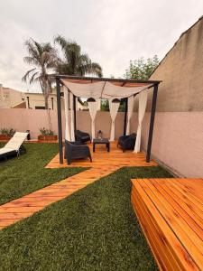 a wooden deck with a gazebo in a backyard at QUINTA BELEN Cañuelas in La Porteña