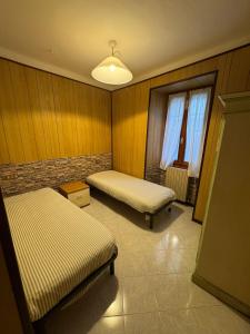une chambre avec deux lits et une fenêtre dans l'établissement Casa Bruna 2 a 25 minuti da Bormio e 15 min da Tirano, à Vervio