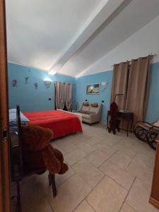 a bedroom with a red bed and a couch at Farfalle in fiore Guesthouse in Roccasecca