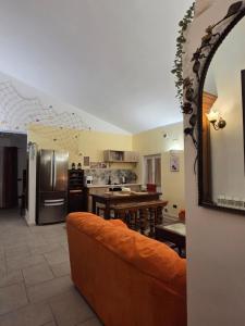 a living room with an orange couch in a kitchen at Farfalle in fiore Guesthouse in Roccasecca