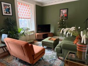 un soggiorno con divano verde e albero di Natale di Arbroath luxury apartment in MCM style ad Arbroath