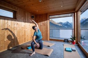 a woman in a room with yoga mats at Berg'k'hof Kaisertal - Alpine Hideaway in Ebbs