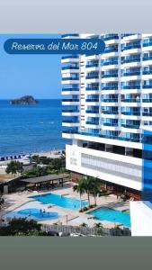een uitzicht op een hotel met een zwembad en de oceaan bij Apartamento Reserva del Mar in Santa Marta