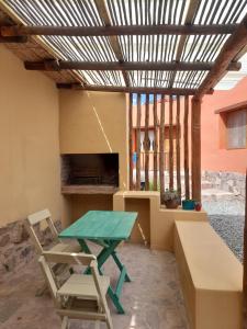 a patio with a table and a chair and a bench at La Cabañita de Tilcara in Tilcara