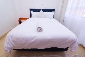 a white bed with white sheets and pillows at Modern 1BR Apartment in Membley & near Ruiru Bypass, Kenyatta University & AMREF, Fast WiFi & Parking-Ruiru Membley in Ruiru