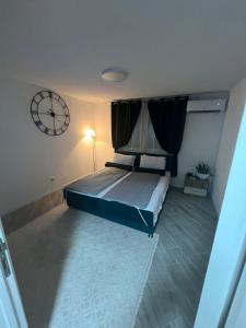 een slaapkamer met een bed met een klok aan de muur bij A&A Apartments in Sarajevo