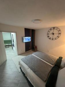 een slaapkamer met een groot bed en een klok aan de muur bij A&A Apartments in Sarajevo