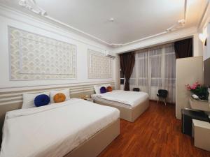 een hotelkamer met twee bedden en een televisie bij The Lake Silk Hanoi Boutique Hotel & Spa in Hanoi