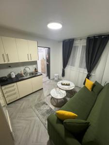een woonkamer met een groene bank en een keuken bij A&A Apartments in Sarajevo