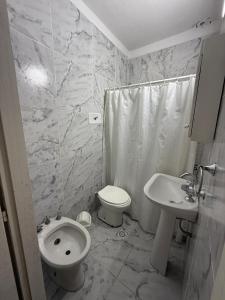 een witte badkamer met een toilet en een wastafel bij Hotel Santa Elena in San Clemente del Tuyú +21 foto's