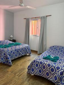 een slaapkamer met twee bedden en een raam bij Hotel Santa Elena in San Clemente del Tuyú