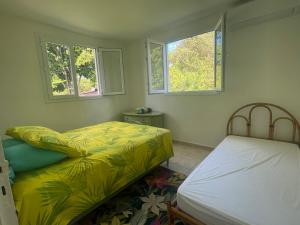 two beds in a room with two windows at Rayon des îles bien désirée in Saint-François