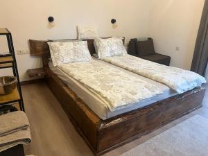 a bed with a wooden frame and pillows on it at Rilski Chardak in Sapareva Banya
