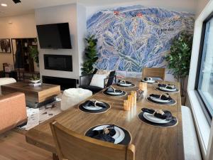 een woonkamer met een houten tafel met borden erop bij Luxe Escape - At Powder Mountain in Sundown Condominiums at Powder Mountain