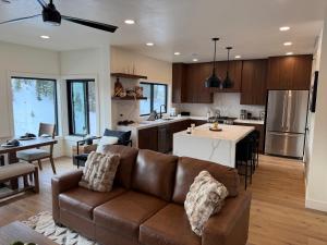 een woonkamer met een bank en een keuken bij Luxe Escape - At Powder Mountain in Sundown Condominiums at Powder Mountain