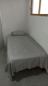 a bed in a white room with a window at Casa alexander in Acapulco