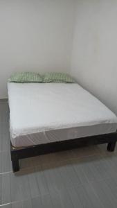 a bed in a room with a white mattress at Casa alexander in Acapulco