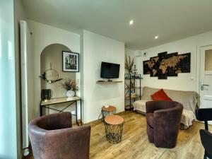 a living room with two chairs and a couch at Au Balcon de la Basilique in Boulogne-sur-Mer +8 photos