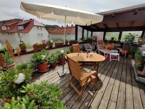 een houten terras met een tafel en een parasol bij Ferienwohnung Leo in Eschwege +8 foto's