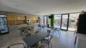 ein Zimmer mit Tischen und Stühlen sowie einer Küche in der Unterkunft Casa Mathias in Eforie Nord
