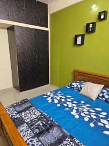 a bedroom with a bed and a green wall at Rove Haven Condo in Bangalore