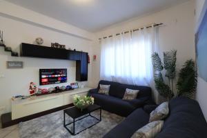 een woonkamer met een bank en een tv bij Casa vacanze Ciachea Home - con BBQ , Parcheggio gratuito , A 10 min Da Palermo & Aeroporto in Carini