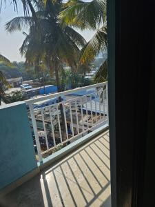 a balcony with a view of the beach and palm trees at Rove Haven Condo in Bangalore