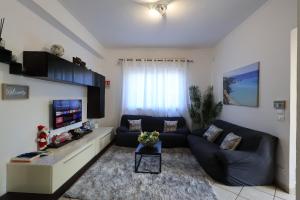 een woonkamer met een bank en een tv bij Casa vacanze Ciachea Home - con BBQ , Parcheggio gratuito , A 10 min Da Palermo & Aeroporto in Carini +44 foto's